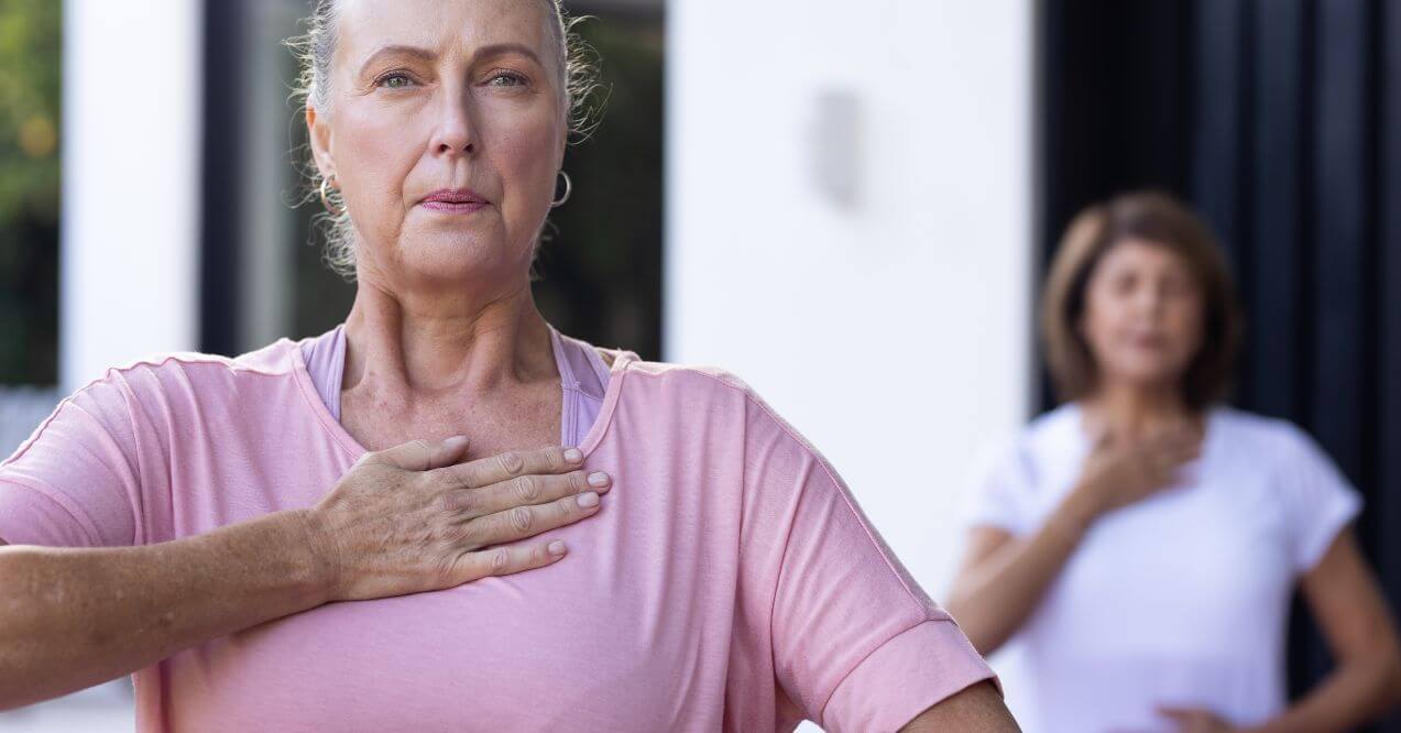 Woman practicing breathing exercises outdoors for relaxation and health benefits.