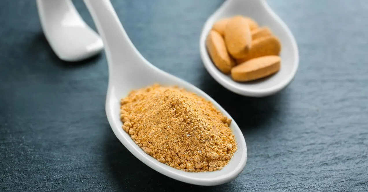 Camu camu supplement powder and tablets on spoon.