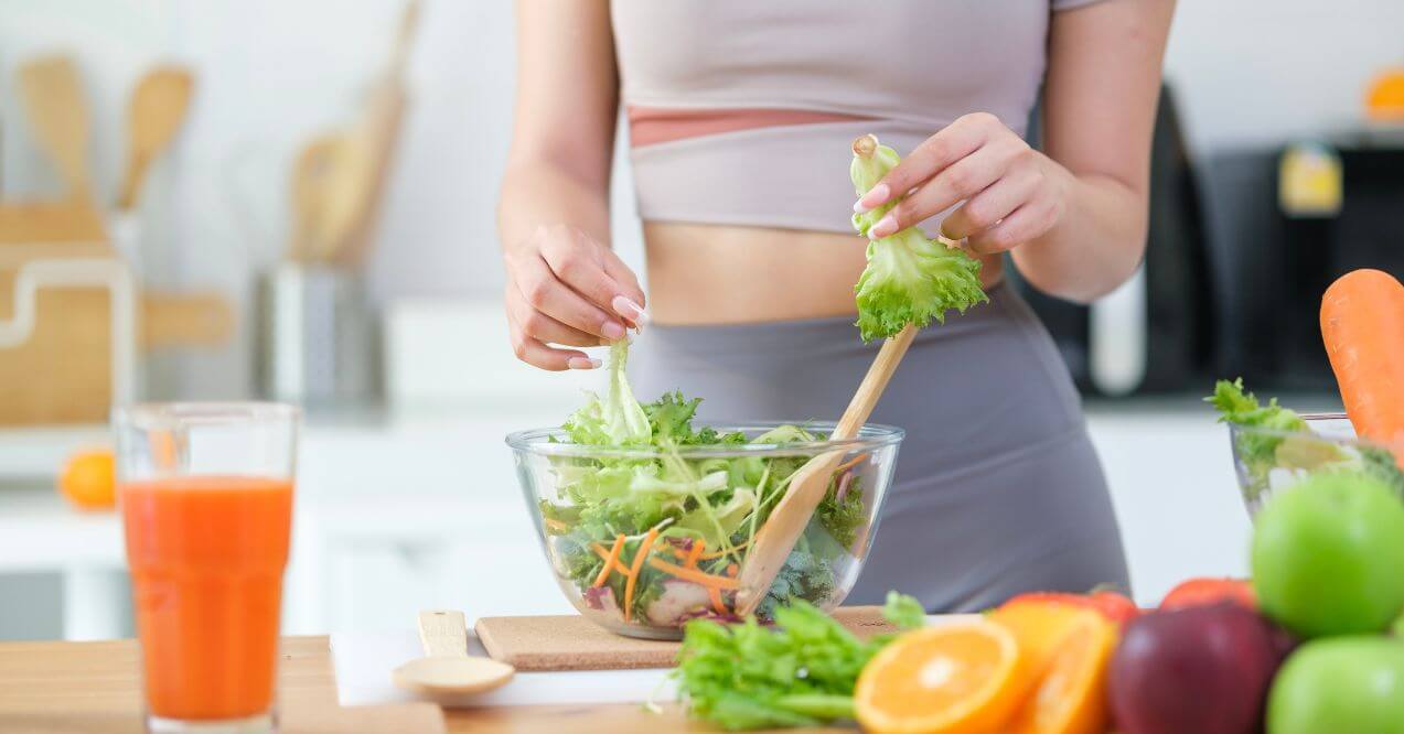 Preparing a fresh salad with leafy greens and vegetables for a healthy diet.