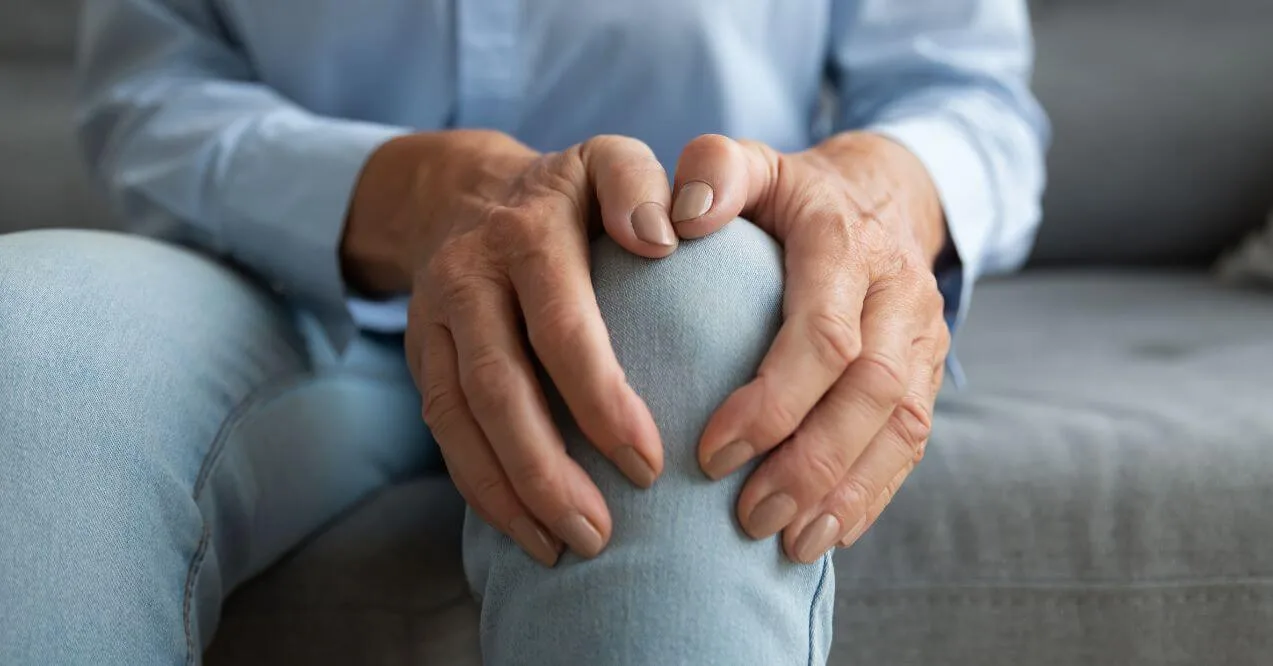 Close-up of hands on knee to show inflammation.