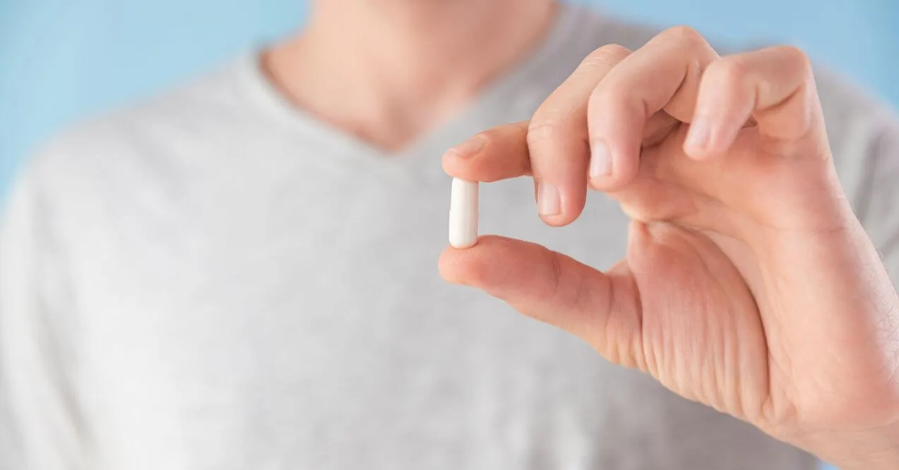 Person holding a pentadecanoic acid supplement for health support.