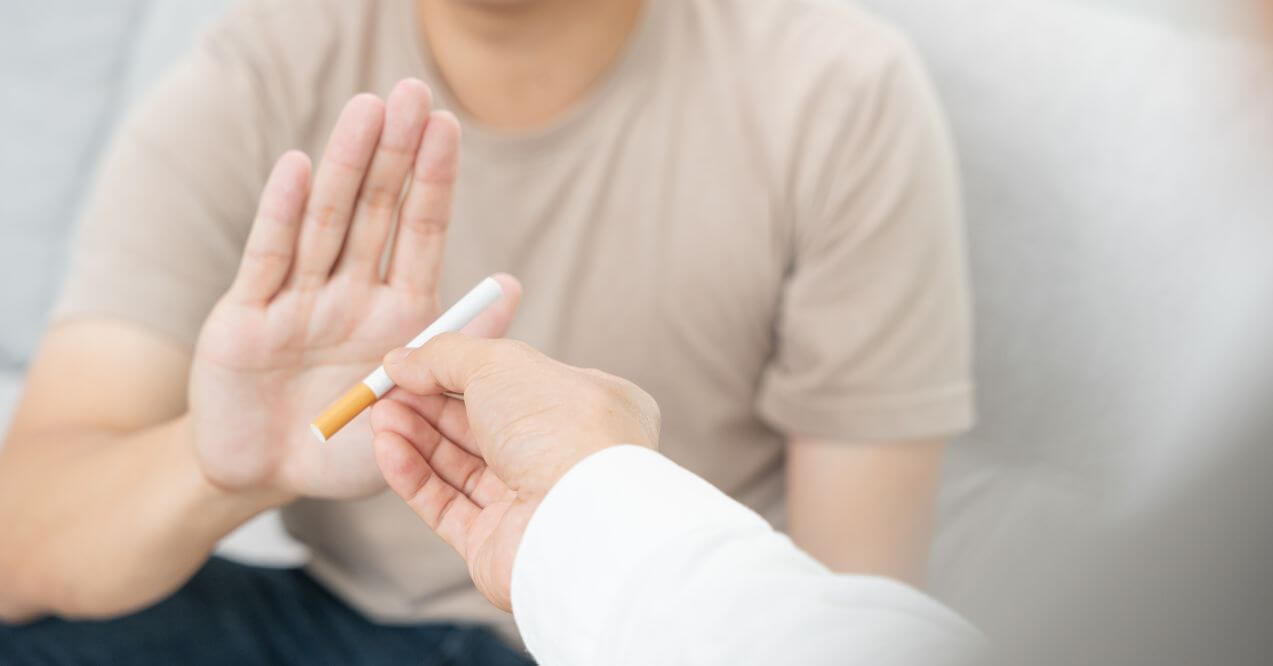 A man refusing a cigarette as part of his journey to quit smoking.