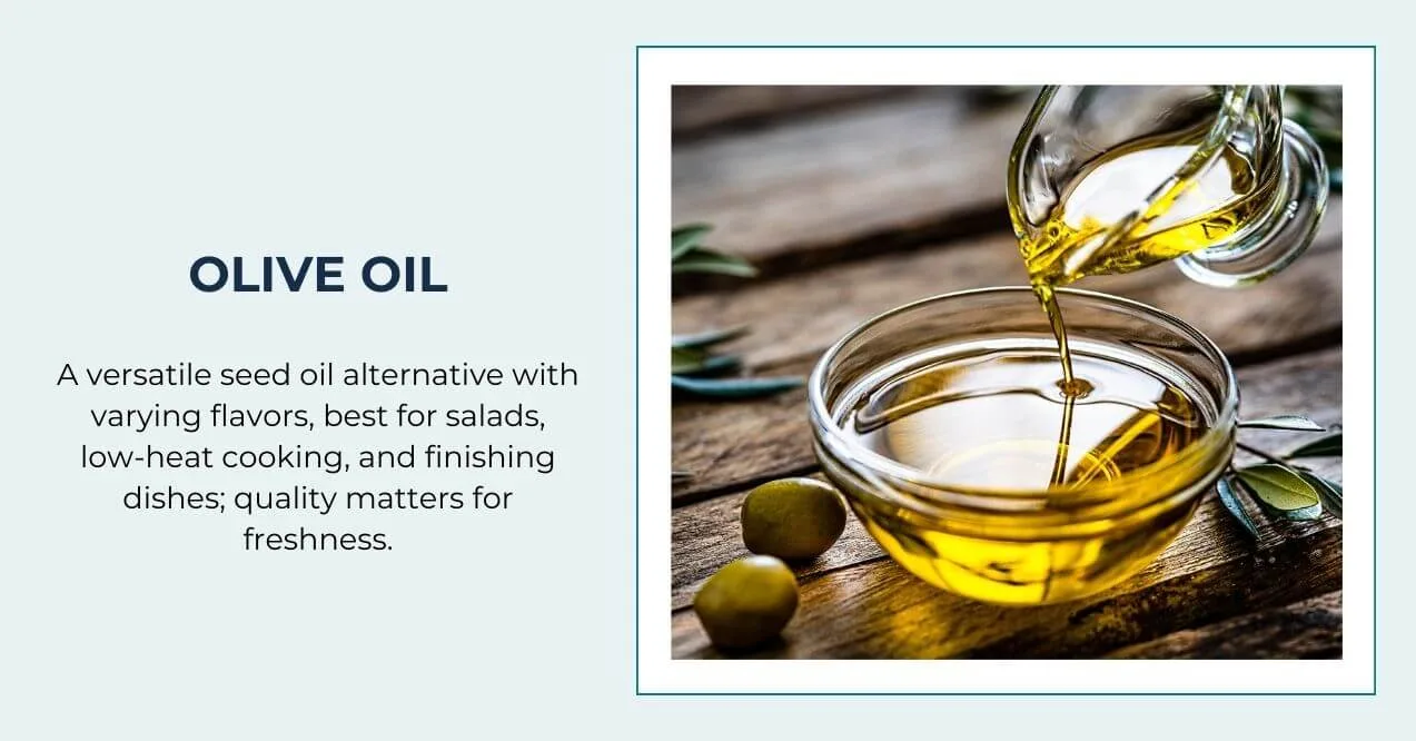 Olive oil being poured into a glass bowl with fresh olives on a wooden table.