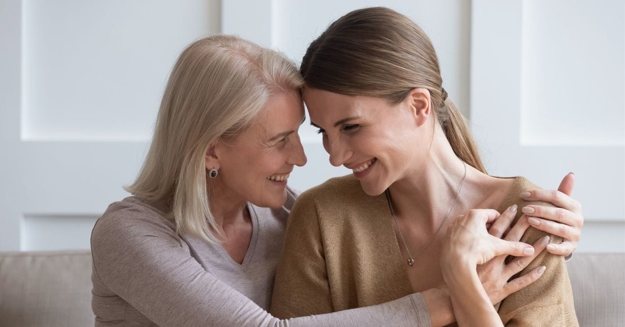 Image of two women embracing, their faces expressing joy and support.