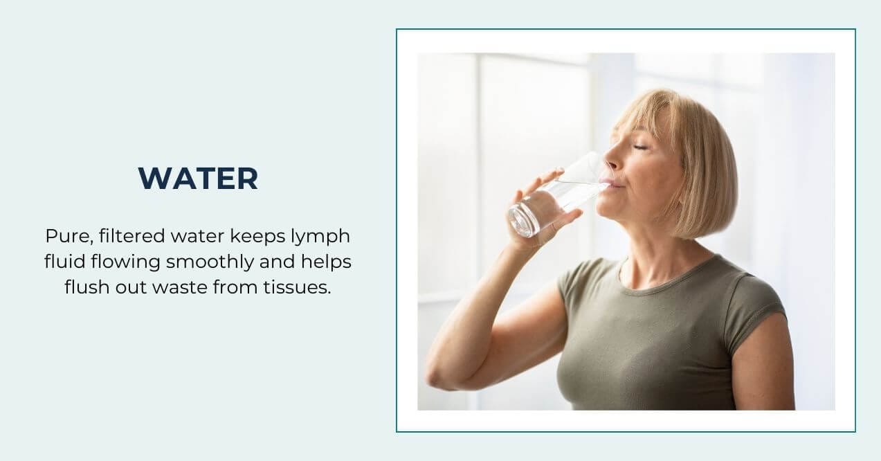 Woman drinking a glass of water by a bright window.