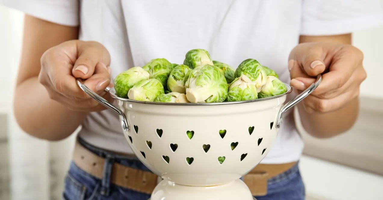 Person holding a colander filled with fresh Brussels sprouts resembling are brussel sprouts good for memory.