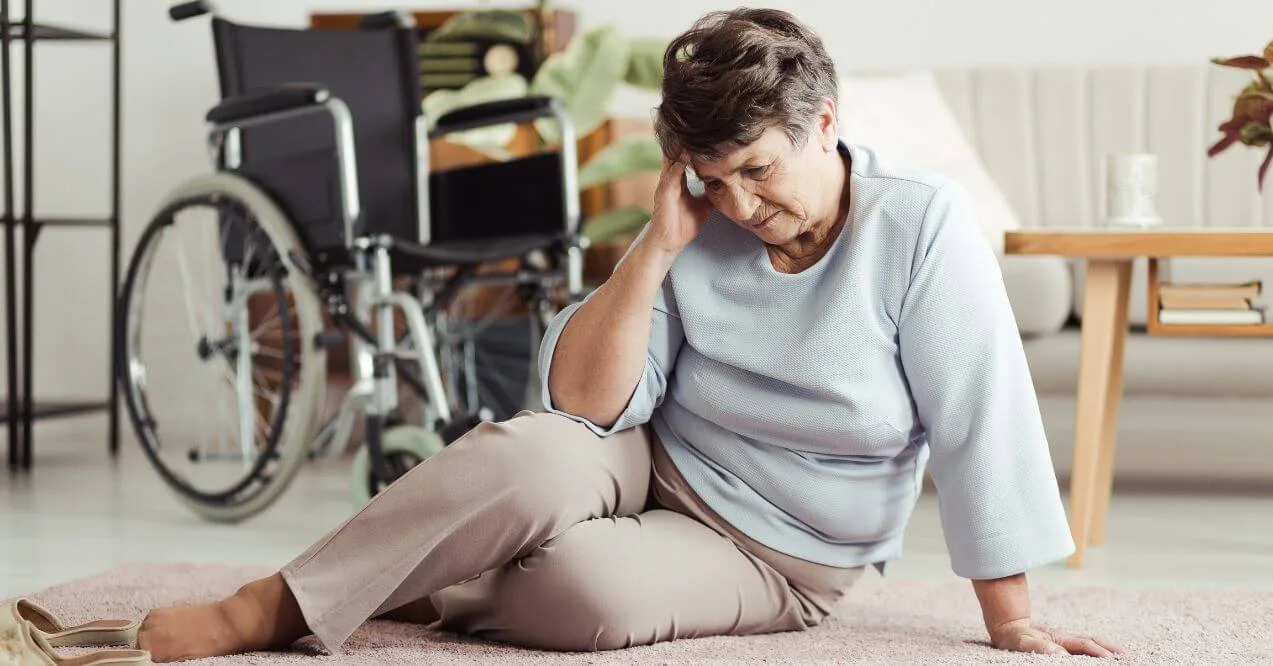 Elderly woman sitting on the floor after a fall, showing balance issues in elderly.