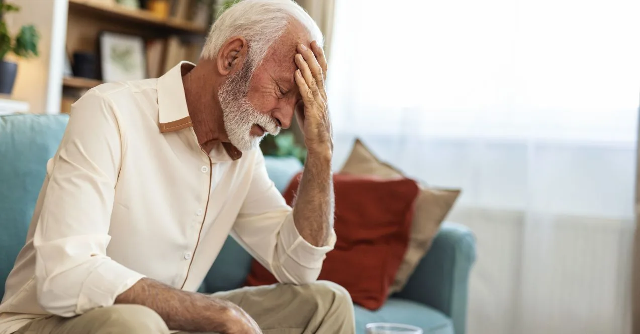 Older man showing signs of discomfort, possibly from Parkinson's non-motor symptoms.