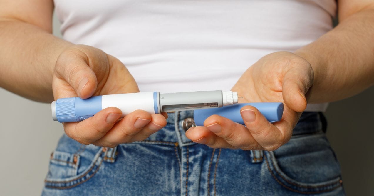 Person holding Ozempic injection pen representing natural alternative to Ozempic
