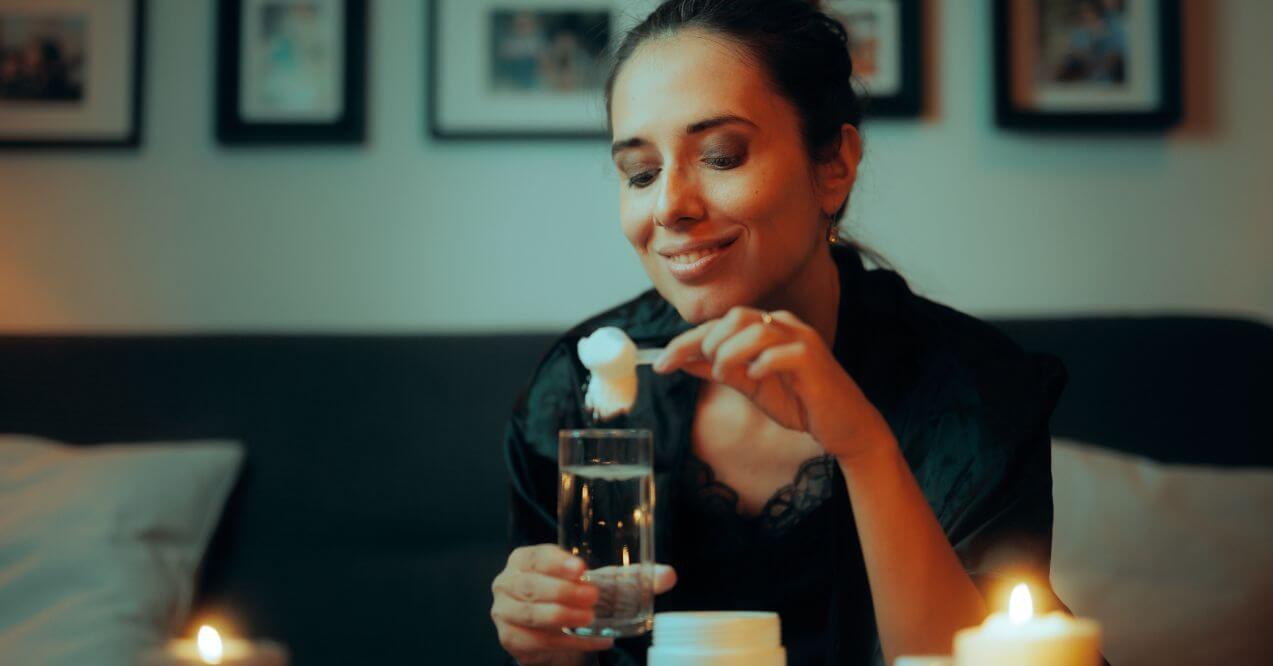 Woman mixing collagen powder into a glass of water resembling hydrolyzed collagen vs collagen peptides difference