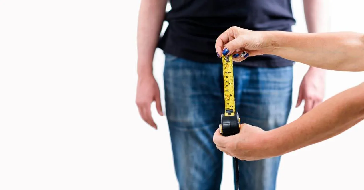 Person measuring waist with tape, wondering what size of prostate is dangerous