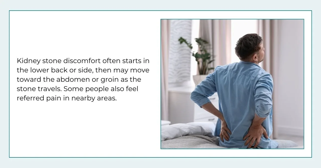 Man sitting on a bed holding his lower back, showing discomfort